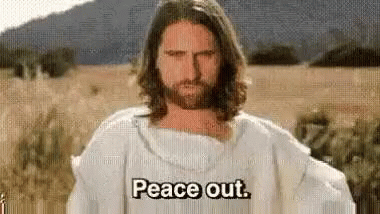 A Man With Long Hair And A Beard Is Wearing A White Robe And Saying Peace Out . GIF