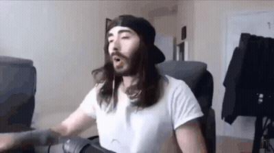 A Man With Long Hair And A Beard Is Wearing A White Shirt And A Black Hat . GIF