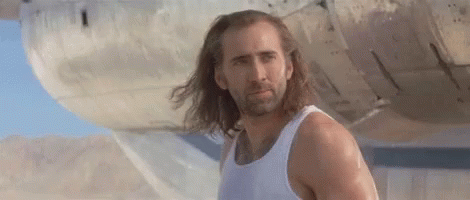 A Man With Long Hair And A Beard Is Wearing A White Tank Top . GIF