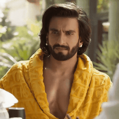 A Man With Long Hair And A Beard Is Wearing A Yellow Robe With The Word Gucci On It GIF