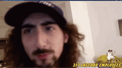 A Man With Long Hair And A Beard Is Wearing Red Lipstick And A Baseball Cap . GIF