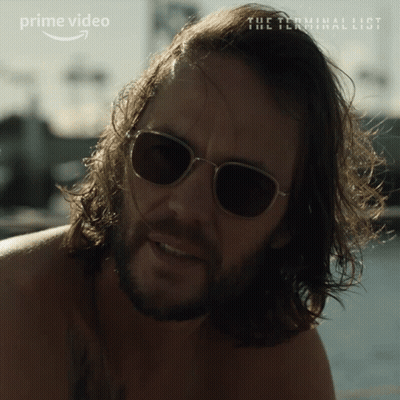 A Man With Long Hair And A Beard Is Wearing Sunglasses And A Prime Video Ad Is Behind Him GIF