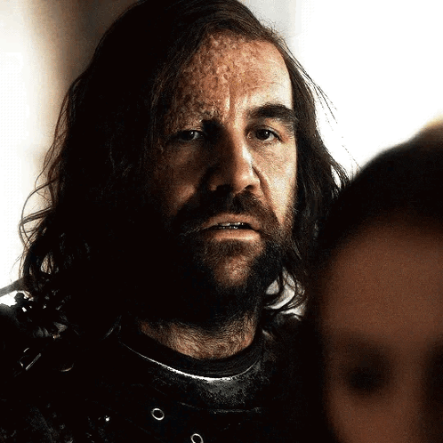 A Man With Long Hair And A Beard Looks At Another Man GIF