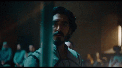 A Man With Long Hair And A Beard Looks At Something GIF