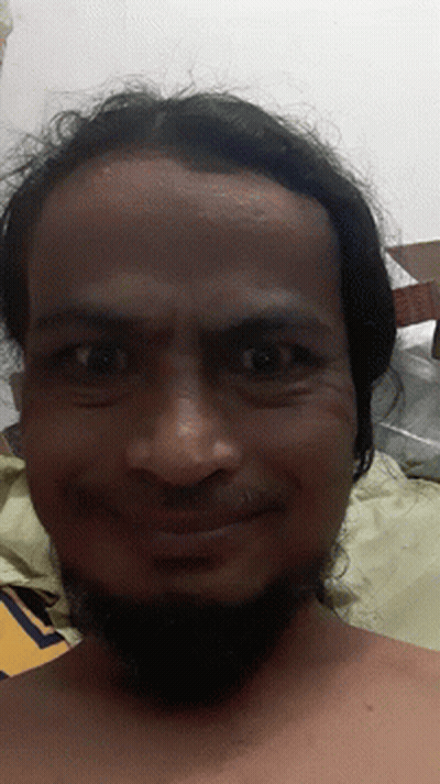 A Man With Long Hair And A Beard Looks At The Camera With A Cardboard Box In The Background GIF