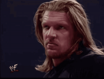A Man With Long Hair And A Beard Looks At The Camera With A Wwe Logo In The Corner GIF