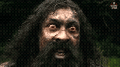 A Man With Long Hair And A Beard Looks At The Camera With The Bone Temple Written On The Bottom Right GIF