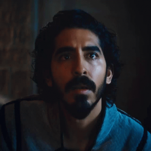 A Man With Long Hair And A Beard Looks Up At Something GIF