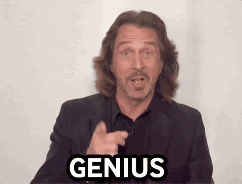 A Man With Long Hair And A Beard Points At The Word Genius GIF