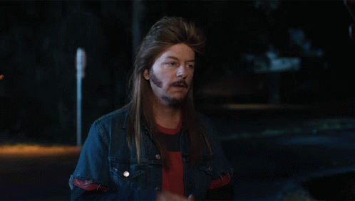 A Man With Long Hair And A Beard Wearing A Blue Denim Jacket GIF