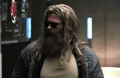 A Man With Long Hair And A Beard Wearing Sunglasses . GIF