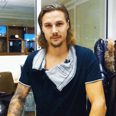 A Man With Long Hair And A Beard Wears A Black Shirt GIF