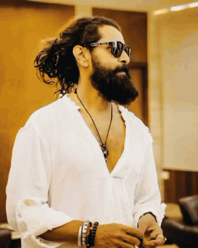 A Man With Long Hair And A Beard Wears A White Shirt And Sunglasses With The Word United On Them GIF