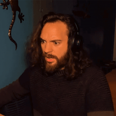 A Man With Long Hair And A Beard Wears Headphones GIF