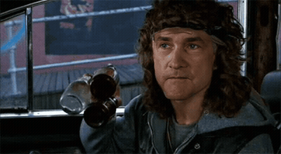 A Man With Long Hair And A Headband Is Sitting In A Car Holding Two Bottles Of Beer . GIF