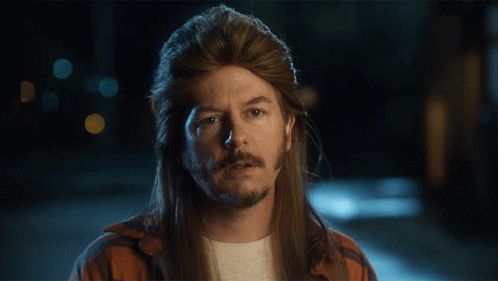 A Man With Long Hair And A Mullet Is Looking Down With His Eyes Closed GIF