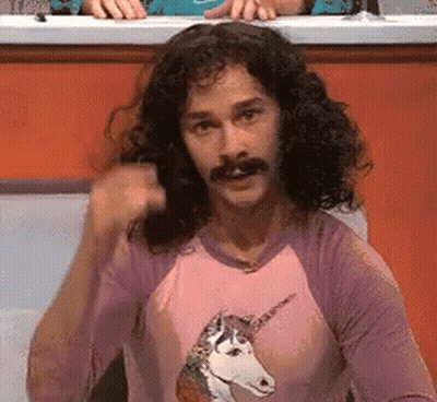 A Man With Long Hair And A Mustache Is Wearing A Unicorn Shirt GIF
