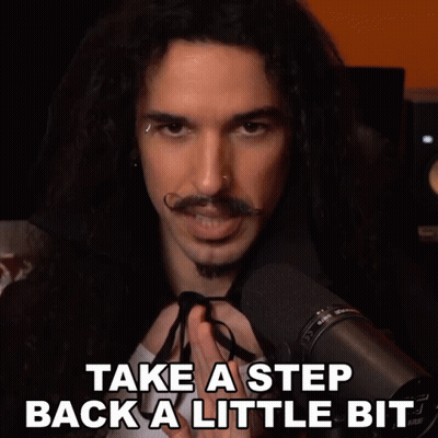 a man with long hair and a mustache stands in front of a microphone with the words take a step back a little bit below h