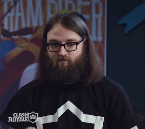 A Man With Long Hair And Glasses Is Wearing A Clash Royale T-Shirt GIF