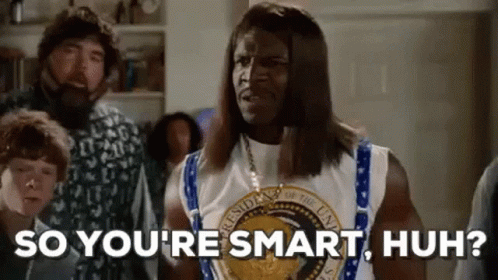 A Man With Long Hair And Suspenders Is Standing In Front Of A Group Of People And Says `` So You 'Re Smart Huh ? '' GIF