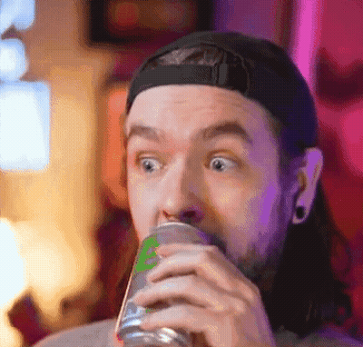 A Man With Long Hair Is Drinking From A Can . GIF