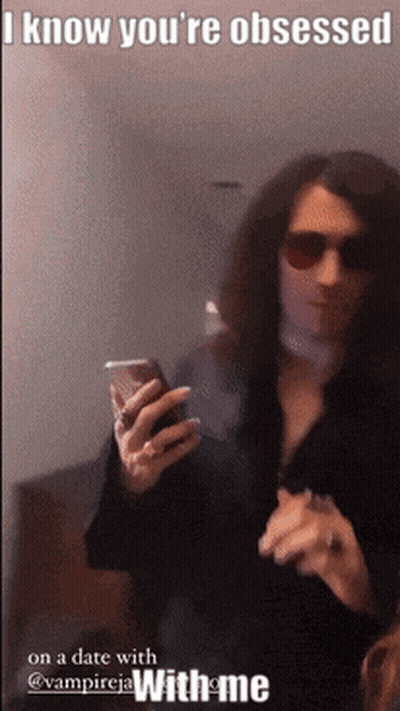 A Man With Long Hair Is Holding A Cell Phone With A Caption That Says I Know You 'Re Obsessed GIF