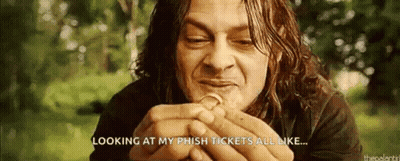 A Man With Long Hair Is Holding A Coin In His Hands . GIF