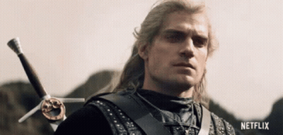 A Man With Long Hair Is Holding A Sword In His Right Hand And Looking At The Camera . GIF