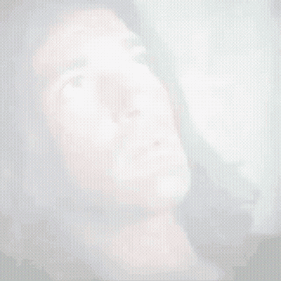 A Man With Long Hair Is Looking Up At Something . GIF