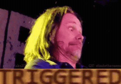 A Man With Long Hair Is Making A Funny Face In Front Of A Sign That Says Triggered GIF
