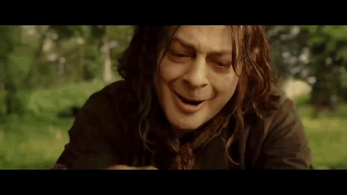 A Man With Long Hair Is Making A Funny Face While Sitting In The Grass . GIF