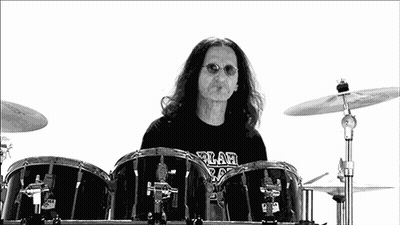 A Man With Long Hair Is Playing Drums With A Shirt That Says ' A ' On It GIF