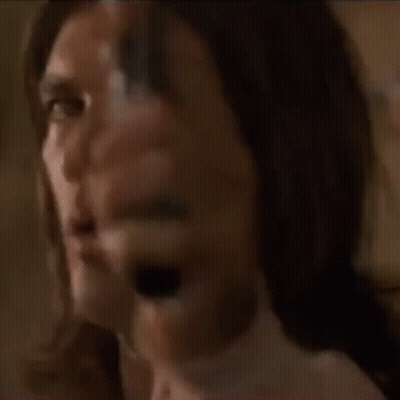 A Man With Long Hair Is Pointing A Gun At Someone GIF