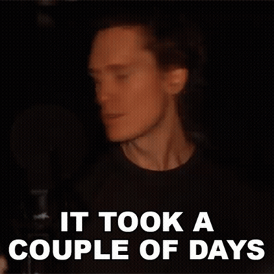 A Man With Long Hair Is Singing Into A Microphone And The Words `` It Took A Couple Of Days '' Are Written Above Him . GIF