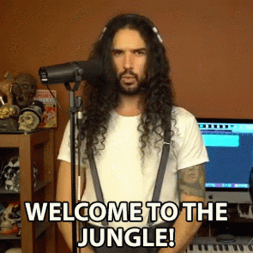 A Man With Long Hair Is Singing Into A Microphone With The Words Welcome To The Jungle Below Him GIF