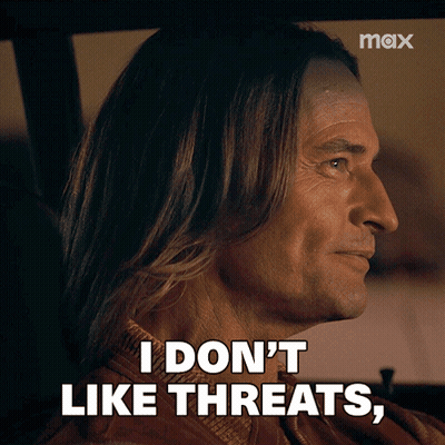 A Man With Long Hair Is Sitting In A Car And Says I Don 'T Like Threats GIF