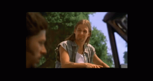A Man With Long Hair Is Sitting In A Car With Another Man GIF
