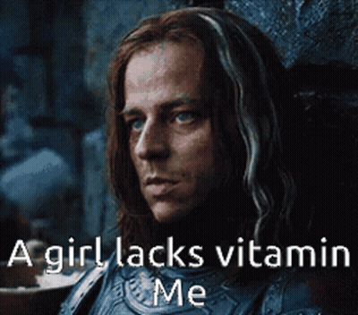 A Man With Long Hair Is Sitting In A Chair With A Caption That Says A Girl Lacks Vitamin Me . GIF