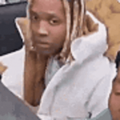 A Man With Long Hair Is Sitting In Front Of A Laptop Computer And Looking At The Camera . GIF