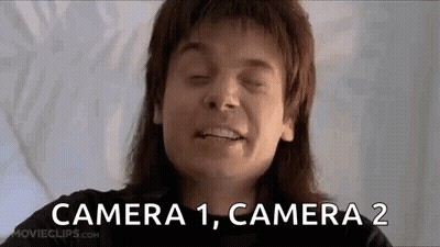 A Man With Long Hair Is Smiling With His Eyes Closed And The Words `` Camera 1 , Camera 2 '' Written Next To Him . GIF