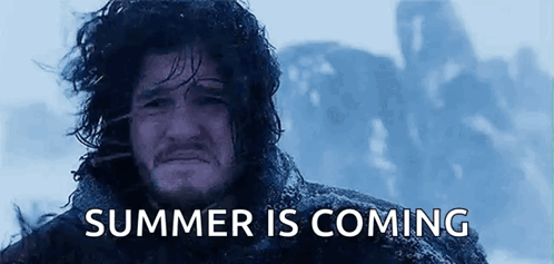 A Man With Long Hair Is Standing In The Snow With The Words `` Summer Is Coming '' Written Above Him . GIF
