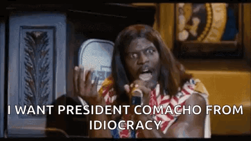 A Man With Long Hair Is Talking Into A Microphone . GIF