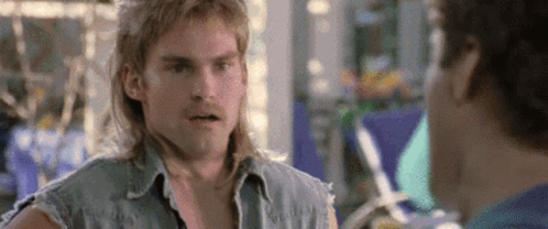A Man With Long Hair Is Talking To Another Man . GIF