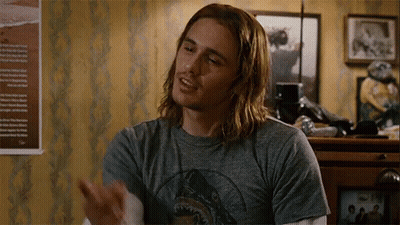 A Man With Long Hair Is Wearing A Shark T-Shirt . GIF