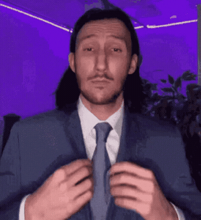 A Man With Long Hair Is Wearing A Suit And Tie GIF