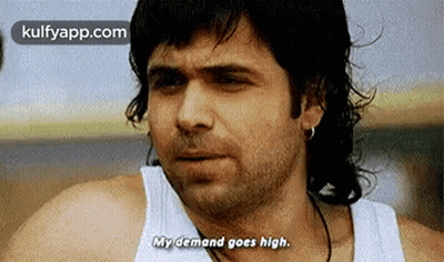 A Man With Long Hair Is Wearing A White Tank Top And Earrings . GIF
