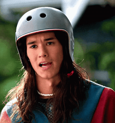 A Man With Long Hair Wearing A Helmet Making A Funny Face GIF