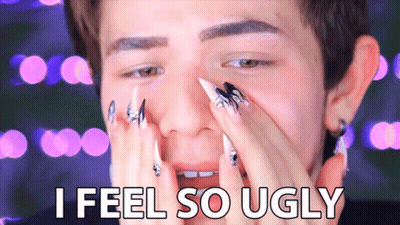 A Man With Long Nails Covering His Face And The Words I Feel So Ugly GIF