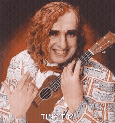 A Man With Long Red Hair Is Holding A Guitar And Smiling . GIF