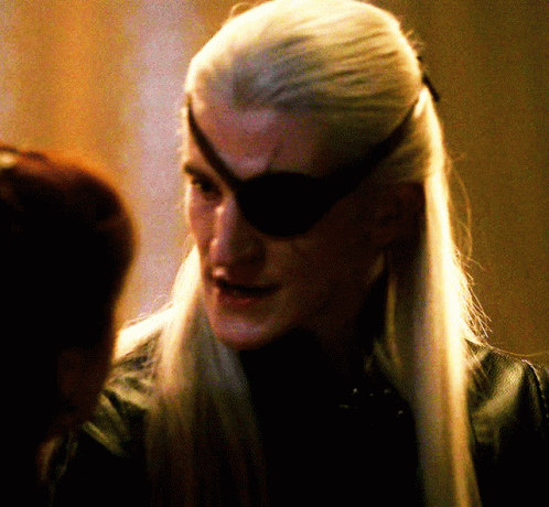 A Man With Long White Hair And A Black Eye Patch On His Forehead GIF